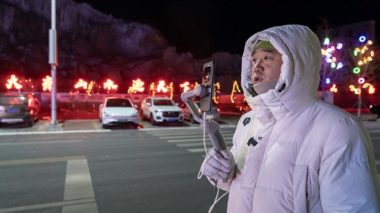 在吉林市阿什哈達(dá)霧凇觀景帶，霧凇播報(bào)員正在直播。新華社記者 李典 攝